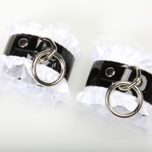 Black and white cuffs with metal rings.